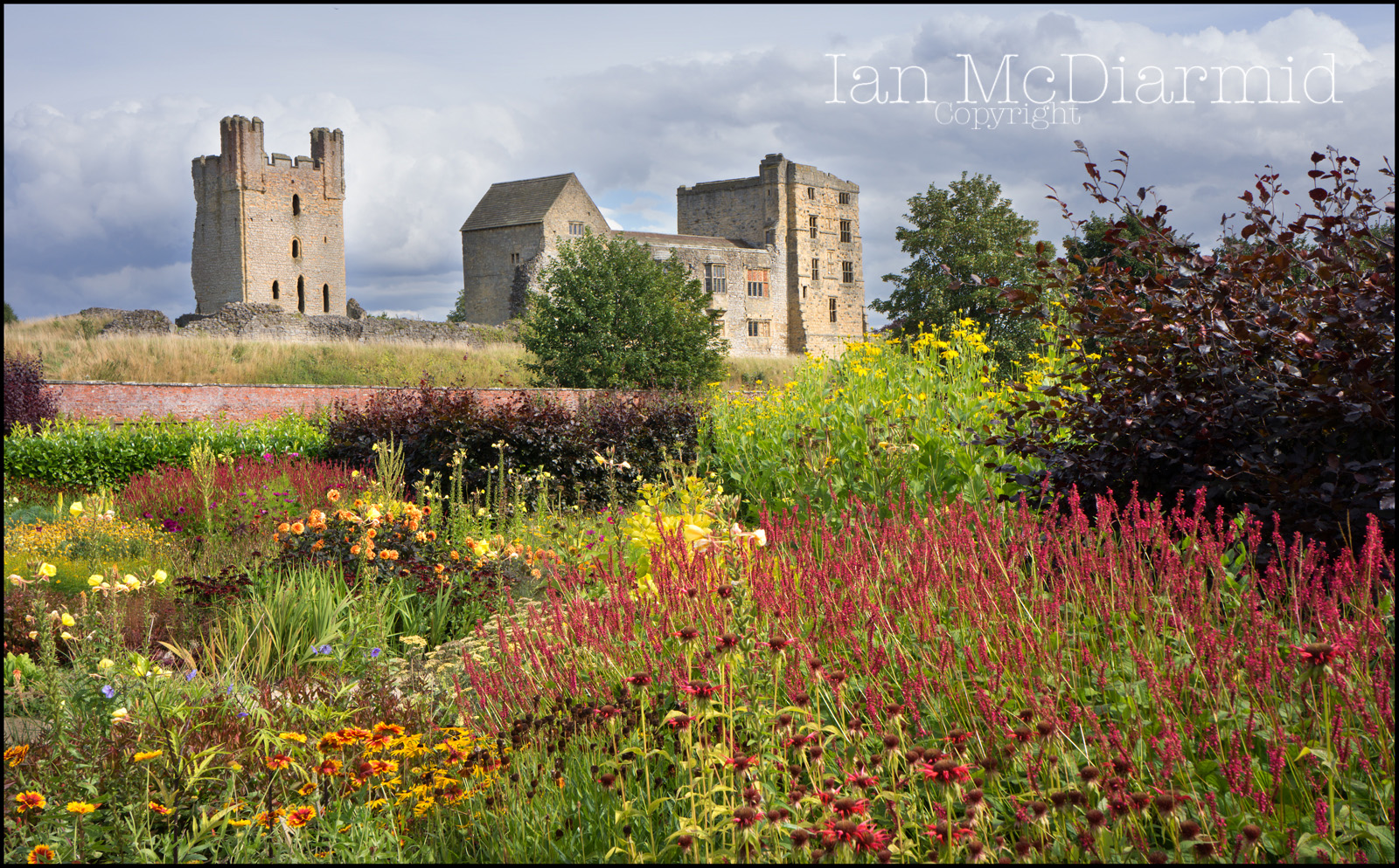 Colourful garden foreground with Helmsley Castle in the background.